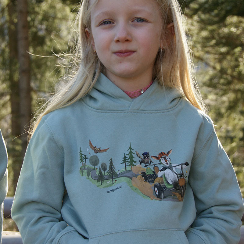 Kind mit hell türkisgrünem Bio-Baumwollhoody im Wald, bequemer und robuster Kapuzenpullover für Abenteuer im Wald