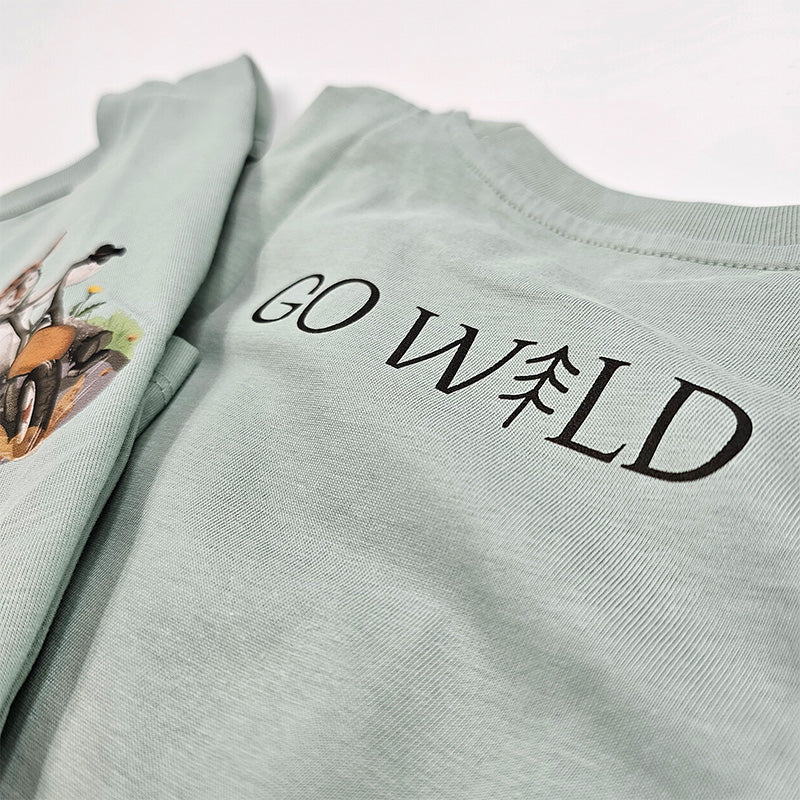 Nahaufnahme des GoWild Schriftzugs auf der Rückseite des grünen T-Shirts, hochwertiger Druck auf Bio-Baumwolle