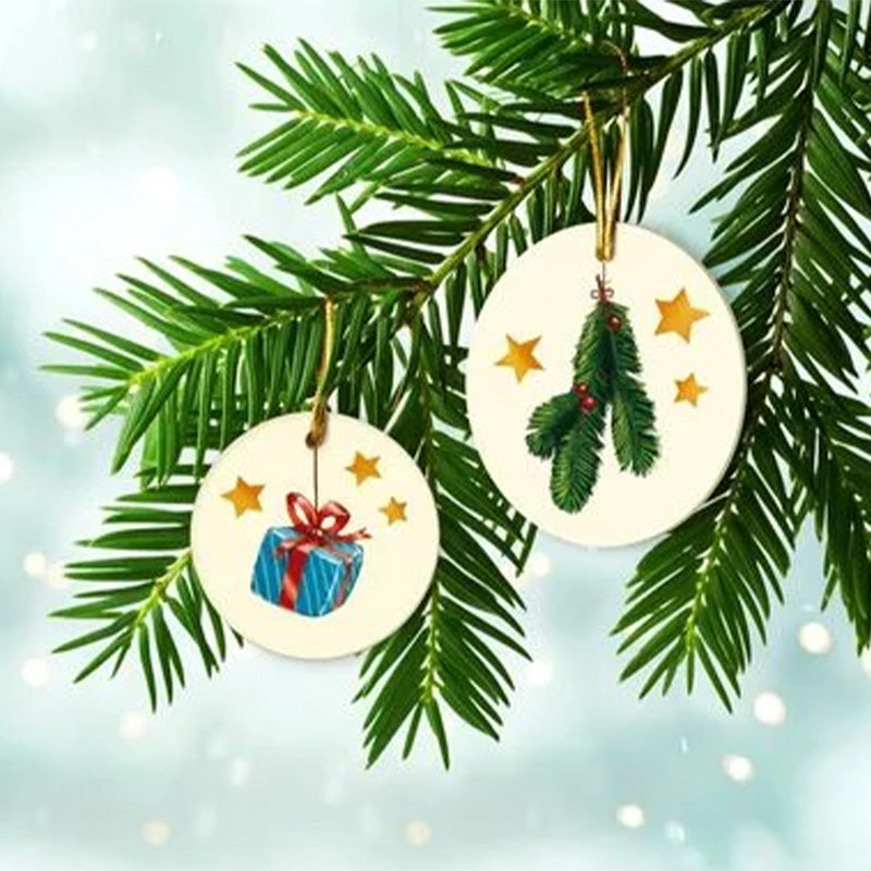 Motivkarte: Zwei runde Anhänger mit festlichen Illustrationen – ein Geschenk und ein Tannenzweig mit Beeren hängen an grünen Tannenzweigen.
