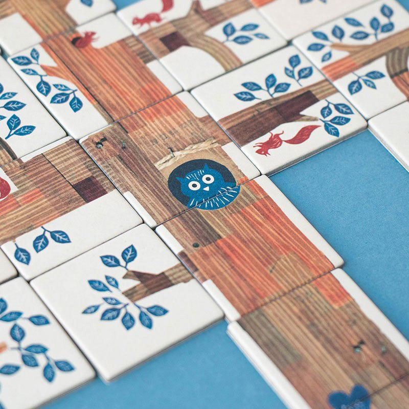 Eine Nahaufnahme der Plättchen mit Baumrinde, Blättern und einer Eule.