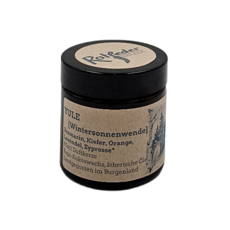 Braunes Glas mit Duftkerze, Etikett mit Aufschrift Yule und botanischer Illustration.