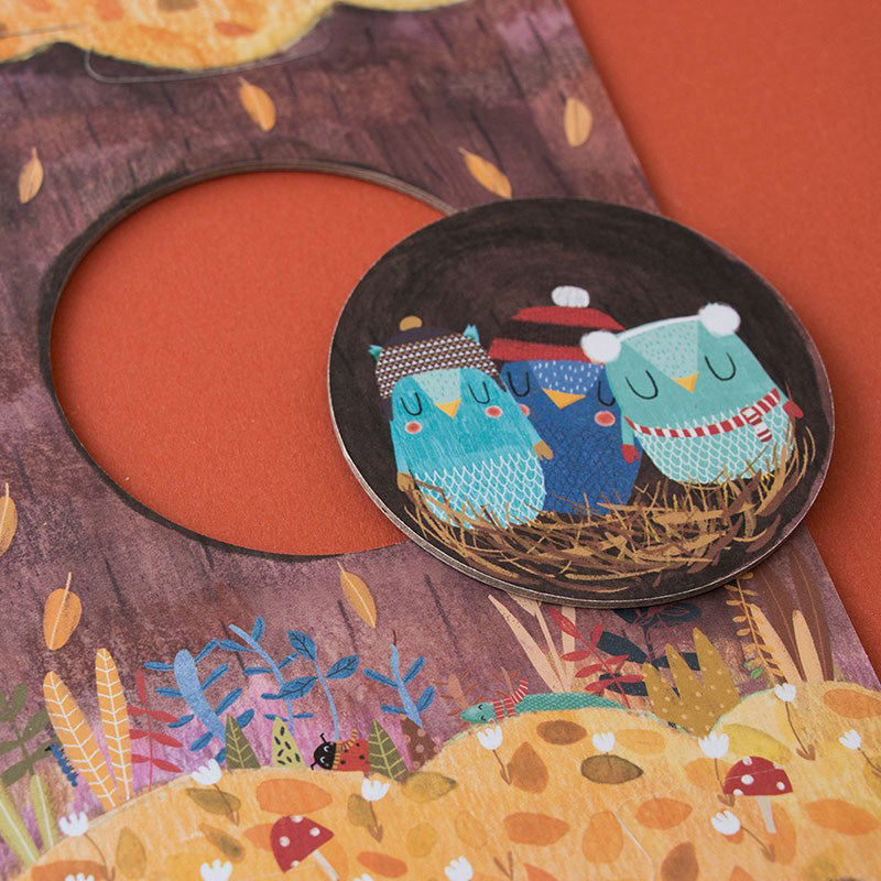 Nahaufnahme eines runden Puzzleteils: drei kleine Eulen im Nest.