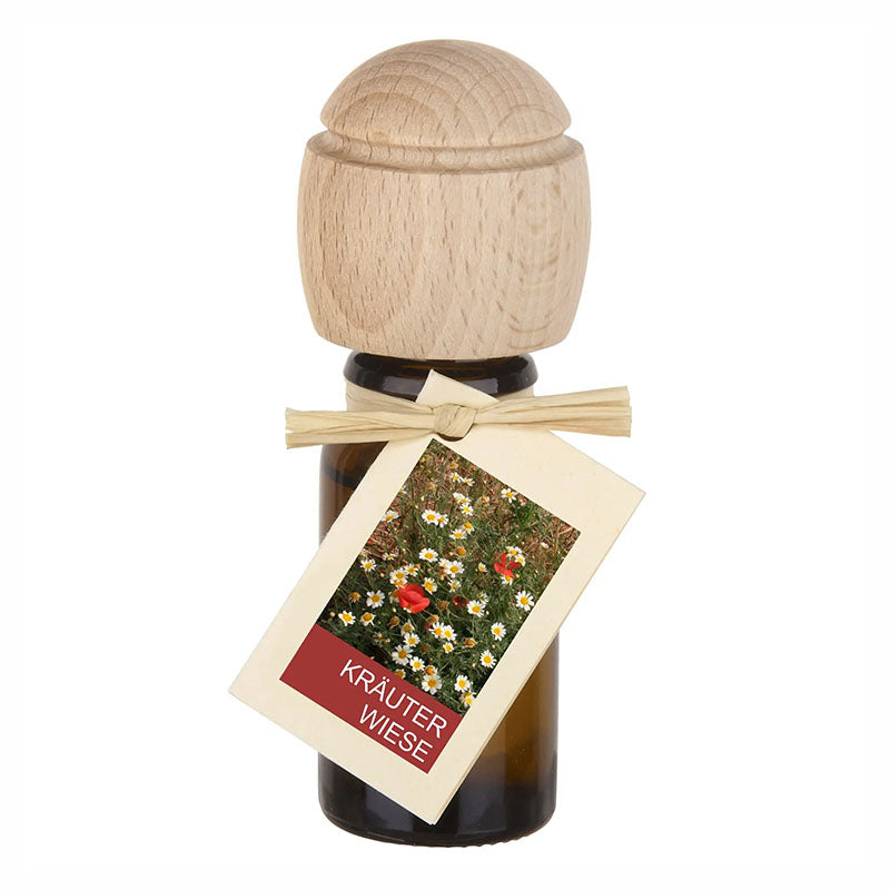 Raumduftflasche mit Holzaufsatz und Etikett Kräuterwiese, zeigt bunte Blüten und Kräuter.