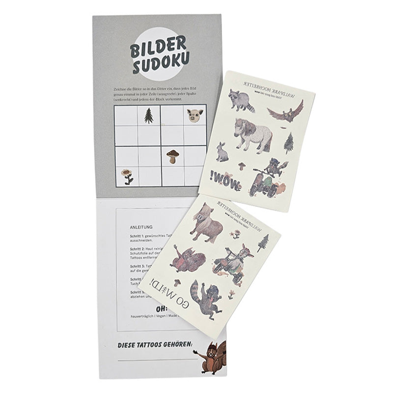Zwei Bögen mit Waldpark Hochreiter-Tattoos liegen auf einer geöffneten grauen Mappe mit einem Bilder-Sudoku-Spiel.
