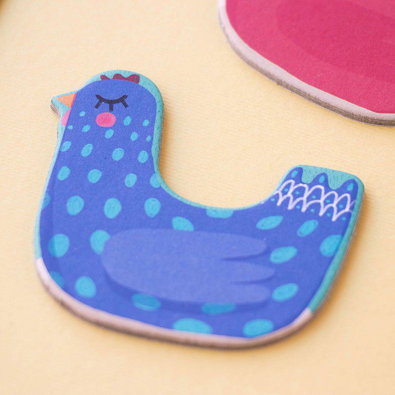 Detailansicht einer blauen Hühnerfigur aus Karton mit Punkten und geschlossenen Augen.