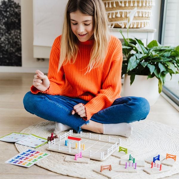 Kind spielt das Spiel Schwing die Hufe am Boden in einer Wohnung