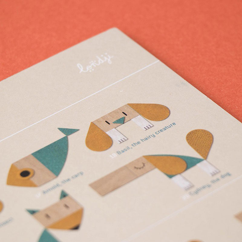 Nahaufnahme der Anleitung des Spiels mit Tieren aus Holzformen, darunter ein Hund und ein Fisch, mit dem Londji-Schriftzug oben.