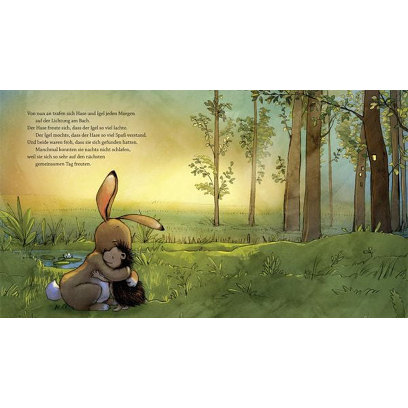 Buchseite: Hase und Igel umarmen sich bei Sonnenaufgang auf einer Lichtung, Wald und Teich im Hintergrund.
