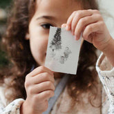 Kind hält ausgedrucktes Sofortbild der Hoppstar Artist vor sich