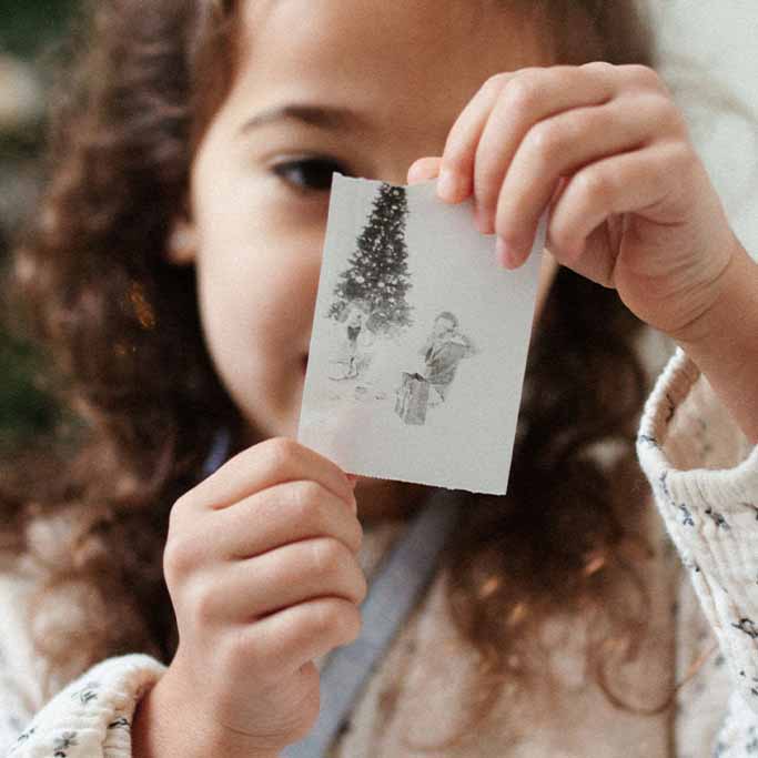 Kind hält ausgedrucktes Sofortbild der Hoppstar Artist vor sich