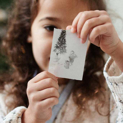 Kind hält ausgedrucktes Sofortbild der Hoppstar Artist vor sich