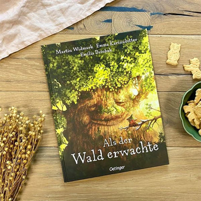 Kinderbuch Als der Wald erwachte von Martin Widmark, Emma Karinsdotter und Emilia Dziubak. Auf dem Cover ist ein riesiger Baum mit Gesicht abgebildet, der freundlich schaut, während ein Kind darunter im Wald sitzt. Verlag: Oetinger.
