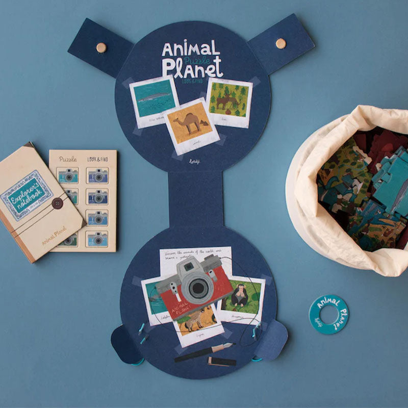 Komplettansicht des Animal Planet Sets, mit Puzzle, Stoffbeutel, Heften und Kameraplättchen auf blauem Untergrund.