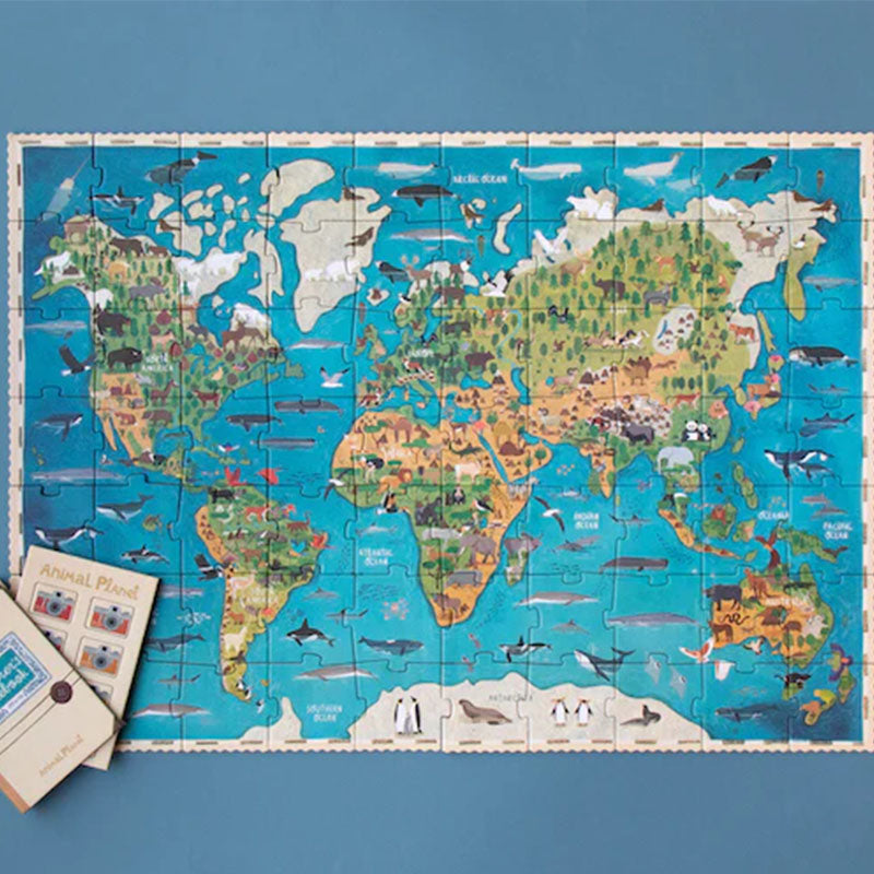 Fertig gelegtes Weltkarten-Puzzle, zeigt Tiere auf allen Kontinenten und Ozeane mit Walen und Fischen.