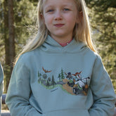 Kind mit hell türkisgrünem Bio-Baumwollhoody im Wald, bequemer und robuster Kapuzenpullover für Abenteuer im Wald