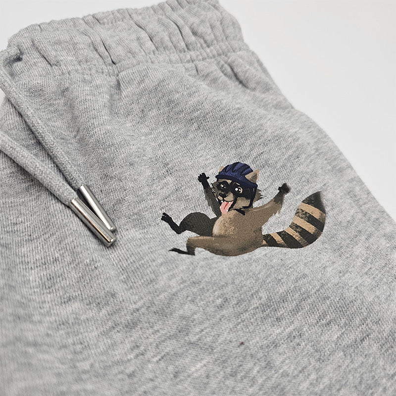 graue Bio-Baumwollhose mit Waschbären-Print, nachhaltige und pflegeleichte Kinderkleidung, auf weißem Hintergrund