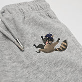 graue Bio-Baumwollhose mit Waschbären-Print, nachhaltige und pflegeleichte Kinderkleidung, auf weißem Hintergrund