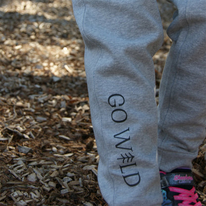 Kind erkundet den Wald in grauer Bio-Baumwollhose mit Waschbär im Sturzhelm und Go-Wild Print, hautfreundliche und flexible Hose für kleine Entdecker