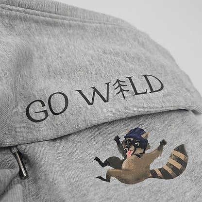 Detailaufnahme des Waschbären-Motivs mit Sturzhelm auf grauer Bio-Baumwollhose, hochwertiger Druck und feine Stoffstruktur, auf weißem Hintergrund.