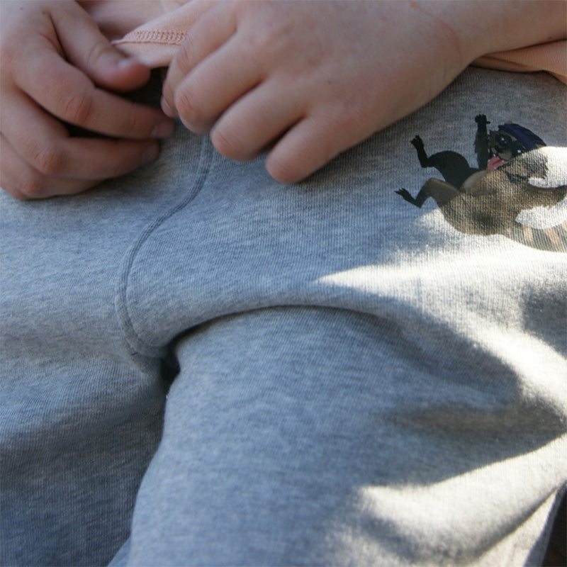 Kinderhose aus grauer Bio-Baumwolle mit Waschbären-Motiv, ideal für Bewegung und Spiel im Freien, natürliche Qualität und hoher Tragekomfort