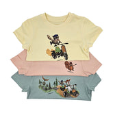 Drei Go Wild T-Shirts in Vorderansicht, gelb Butter, grün Aloe und rosa Peach nebeneinander, zeigt farbenfrohe Kinderabenteuer-Motive.