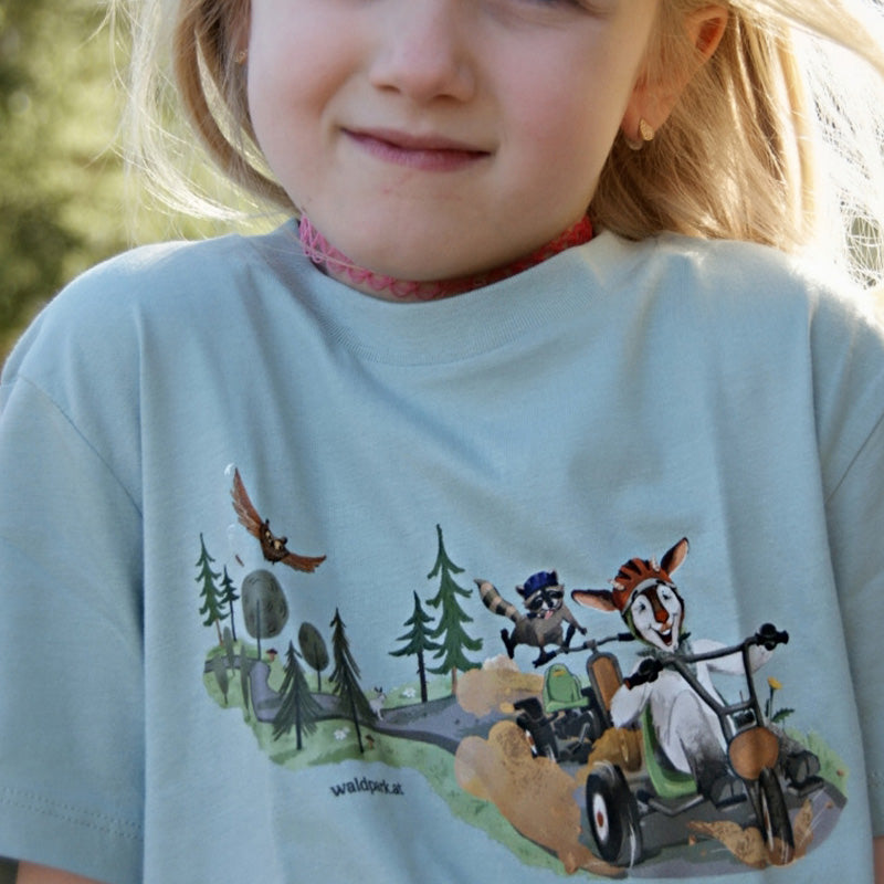 Go Wild Bio-Baumwoll-T-Shirt in Grün, Vorderseite zeigt Ziege und Waschbär im Go-Kart, ideal für Kinder, die Abenteuer und Natur lieben