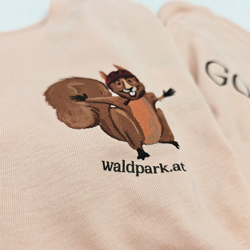 Nahaufnahme des hellrosa T-Shirts, Vorderseite mit mutigem Eichhörnchen auf Abenteuerfahrt, liebevoll illustriert für Kinder