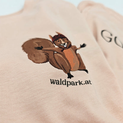 Nahaufnahme des hellrosa T-Shirts, Vorderseite mit mutigem Eichhörnchen auf Abenteuerfahrt, liebevoll illustriert für Kinder