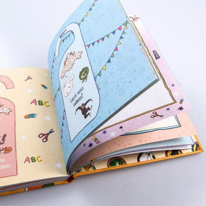 „Geöffnetes Freundebuch Die Schule der magischen Tiere – Meine Freunde. Zu sehen sind bunte, illustrierte Seiten mit Tieren, Buchstaben und Bastelsymbolen. Eine blau gestaltete Seite mit Wimpelgirlanden zeigt den Aufdruck ‚Lass uns toben!‘ sowie kleine Tierzeichnungen.