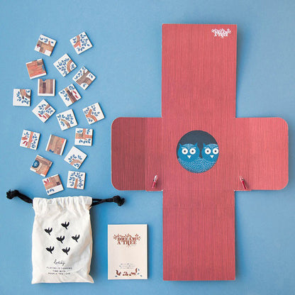 Den Inhalt der Schachtel: aufgeklappte Box mit Eulenmotiv, Beutel, Anleitung und Spielplättchen.