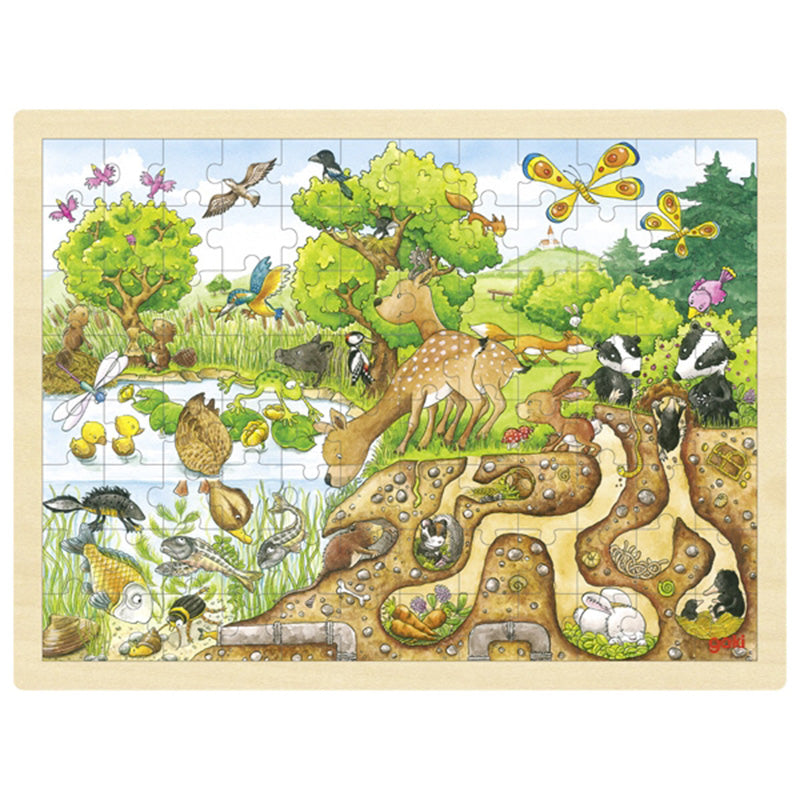 Holzpuzzle mit einer detailreichen Natur- und Tierszene an einem Teich. Zu sehen sind ein Reh, Enten, Schmetterlinge, Vögel und Dachse, außerdem unterirdische Gänge mit verschiedenen Tieren in ihren Höhlen.