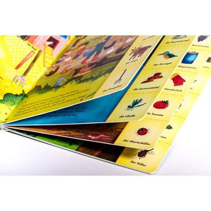 Buchseite Detailansicht. Seiten werden aufgefächert gezeigt mit Bildern von Naturmotiven und Begriffen wie Marienkäfer, Libelle und Gummistiefel.