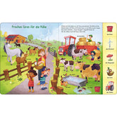 Buchseite „Frisches Gras für die Kühe“. Bauernhofszene mit Kühen, Pferden und Traktor. Viele Begriffe sind beschriftet.