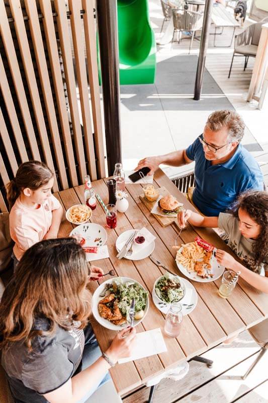 Familie am Tisch mit Speisen_Waldpark Hochreiter
