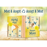 Buchumschlag: Präsentation des Wendebuchs mit dem Text „Mut & Angst ↻ Angst & Mut“, beide Buchseiten sichtbar auf einem Holztisch.