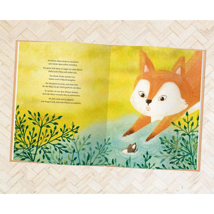 Buchseite: Der Fuchs beugt sich über ein Gewässer, in dem eine kleine Maus im Wasser treibt, umgeben von Pflanzen.