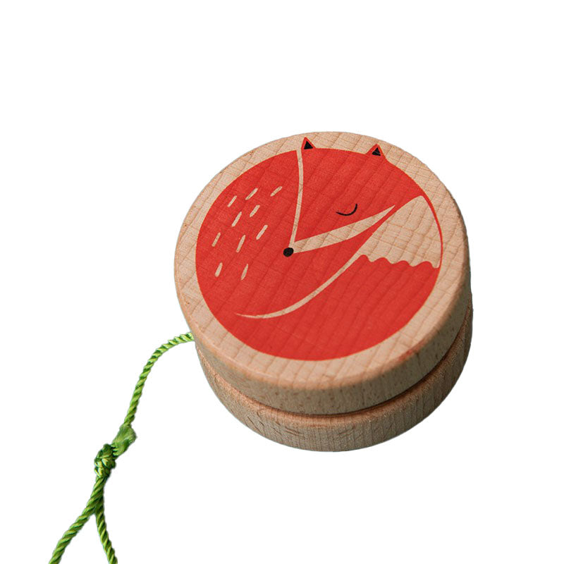 Holz-Yo-Yo mit grünem Faden und aufgedrucktem roten schlafenden Fuchs, freigestellt auf weißem Hintergrund.