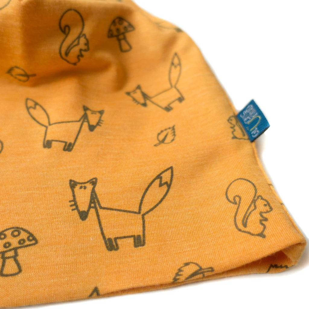 Detailaufnahme der sonnengelben Kinderhaube aus Merinowolle und Seide mit Fuchs-Motiv, zeigt hochwertige Nähte und glatte, weiche Oberfläche