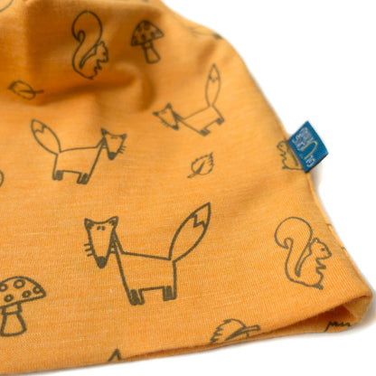 Detailaufnahme der sonnengelben Kinderhaube aus Merinowolle und Seide mit Fuchs-Motiv, zeigt hochwertige Nähte und glatte, weiche Oberfläche