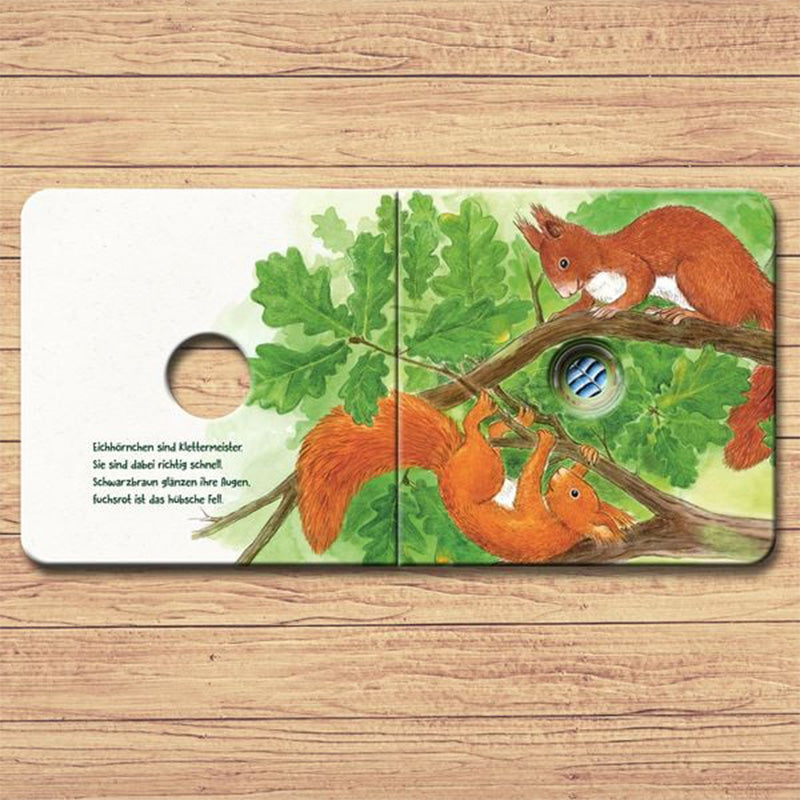 Buchseite mit zwei Eichhörnchen auf einem Ast zwischen grünen Eichenblättern, mit Guckloch.