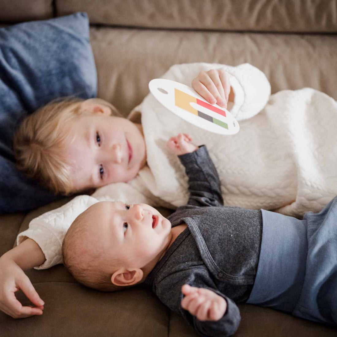 Baby und Kleinkind schauen sich gemeinsam eine Kontrastkarte an