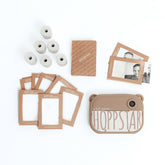 Set-Inhalt der Hoppstar Artist Memo Kamera: Kamera, mehrere Fotopapierrollen, bedruckte Kartenrahmen und eine braune Verpackung.