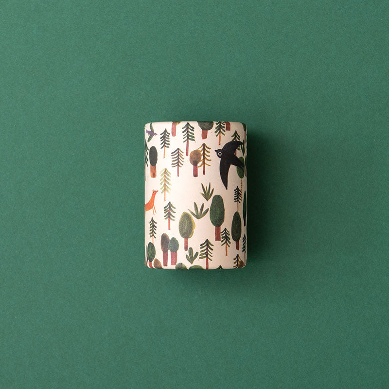 Ein einzelnes Kaleidoskop mit Waldmotiven (Bäume, Vogel, Fuchs) von oben fotografiert.