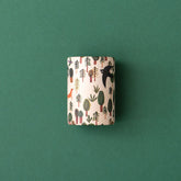 Ein einzelnes Kaleidoskop mit Waldmotiven (Bäume, Vogel, Fuchs) von oben fotografiert.