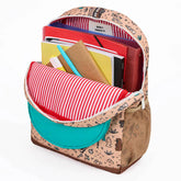 Geöffneter Rucksack, gefüllt mit Heften und Büchern, zeigt das rot-weiß gestreifte Innenfutter.