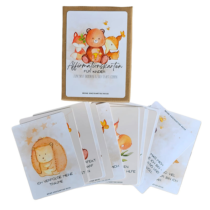 Geöffnete Box der „Affirmationskarten für Kinder“ mit mehreren ausgelegten Karten, die mit Tierillustrationen und positiven Sprüchen gestaltet sind.
