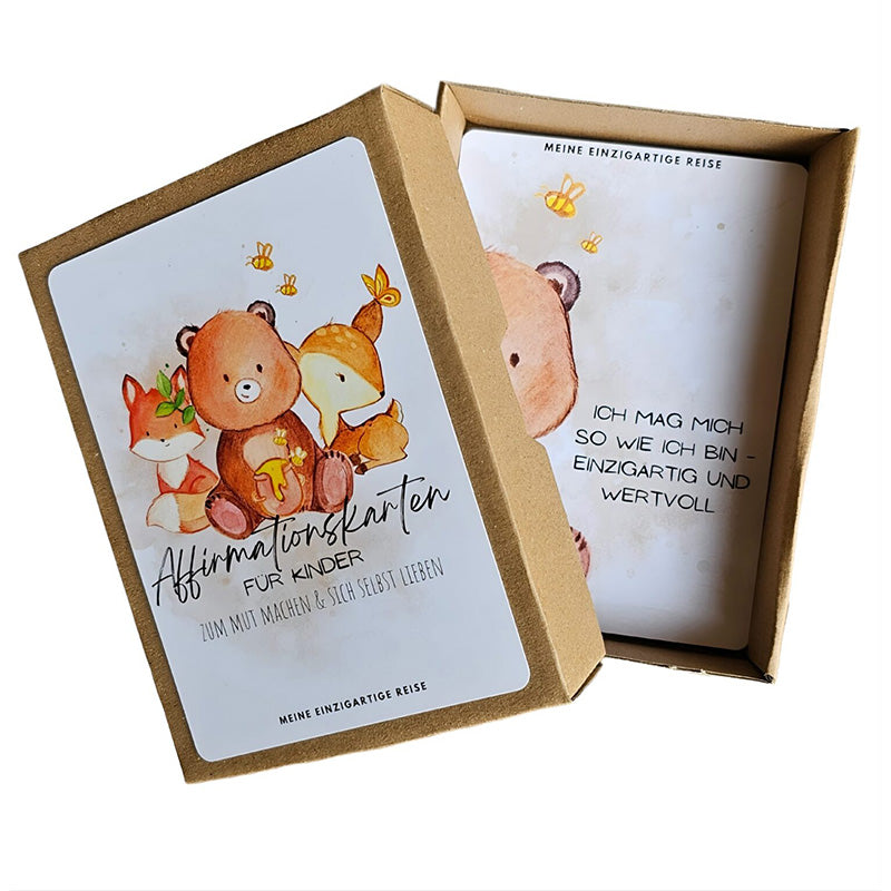 Geöffnete Kartonbox der „Affirmationskarten für Kinder“ mit einer sichtbaren Karte, auf der der Satz „Ich mag mich so wie ich bin – einzigartig und wertvoll“ steht.