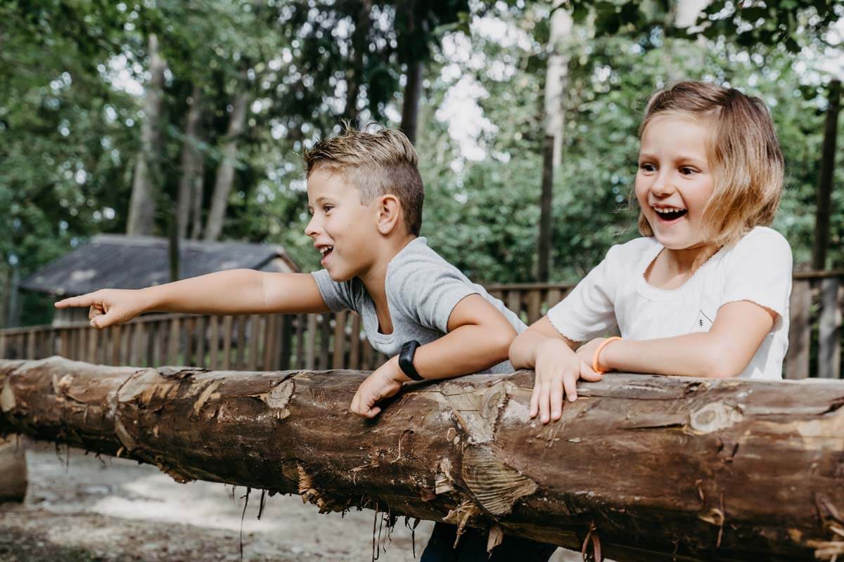 Mädchen und Junge am Holzstamm - Waldpark Hochreiter