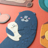 Nahaufnahme eines blauen Otters, der liebevoll ein weißes Otterbaby im Arm hält.