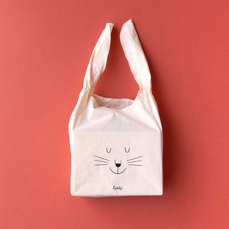 Stofftasche mit Hasengesicht und offenen Griffen auf rotem Hintergrund.